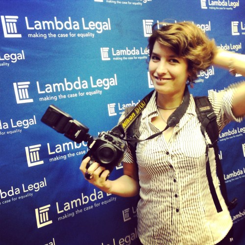 Wedding photographer stands in front of the blue lambda legal back drop at a press conference in san juan.
