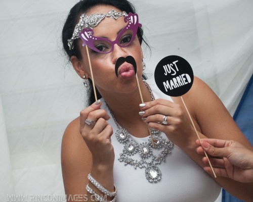 Bride has fun playing with fake mustache and fake eye glasses. The props are made of paper and glued to sticks. She also has a sign that says just married. - wedding photographer puerto rico