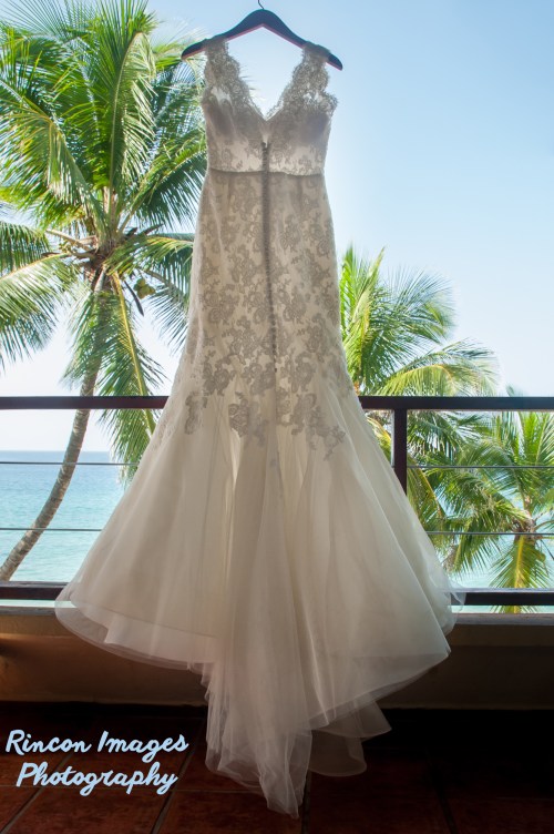 White wedding dress hanging outside with palm trees in the background. wedding photographer rincon puerto rico