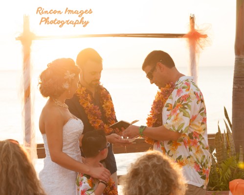 Scott slipping the wedding ring onto Colleens finger and the sun sets during their wedding by the beach in Rincon, Puerto Rico. Wedding photography by Rincon Images wedding photography. Wedding photographer in Rincon Puerto Rico.