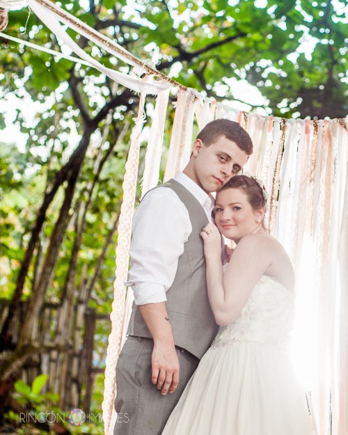 The bride and her groom in front of their DIY wedding ceremony backdrop in Rincon, Puerto Rico.