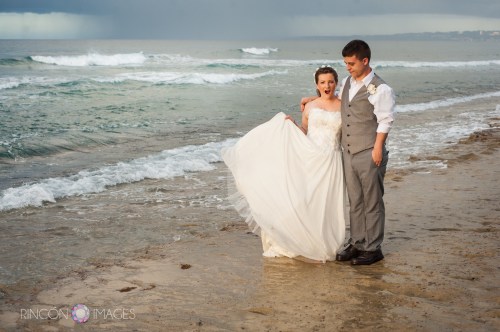 Goofing around on the beach after the ceremony, the bride makes a funny face.