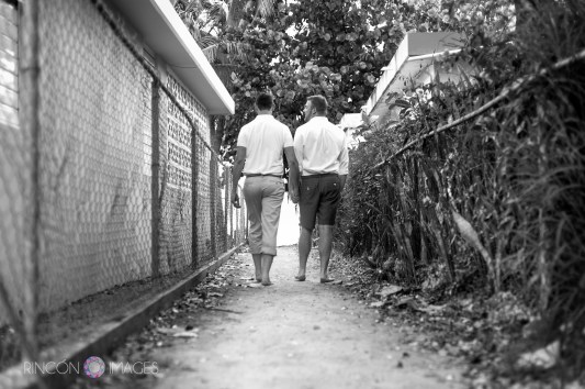 A black and white photograph of the two grooms strolling towards the ocean during their gay wedding photography session in Rincon, Puerto Rico. LGBT wedding photographer Puerto Rico